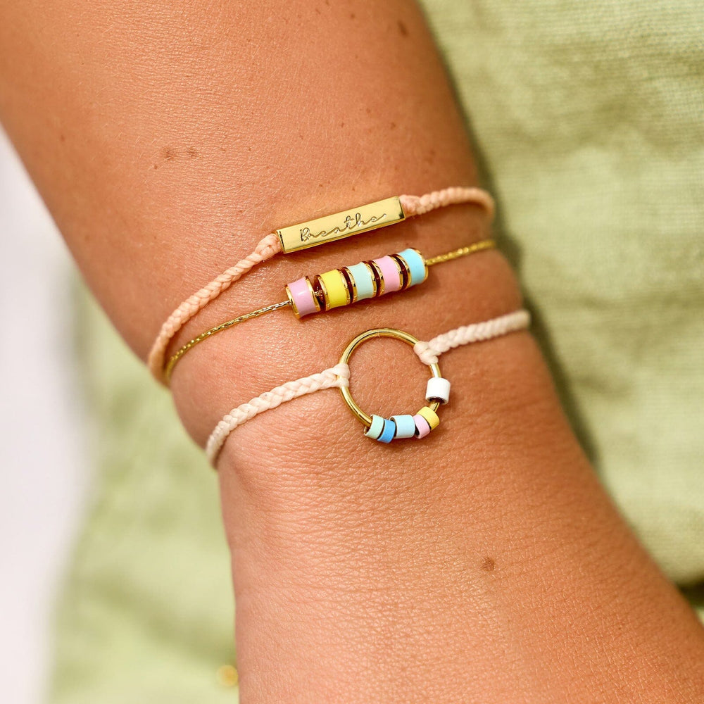 Three colorful bead and rope bracelets on a wrist