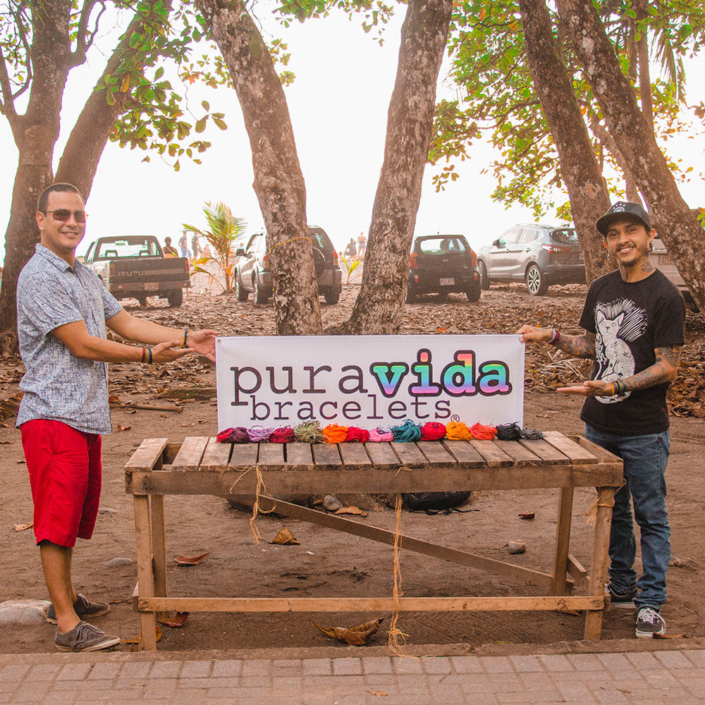 Two artisans with Pura Vida's first logo